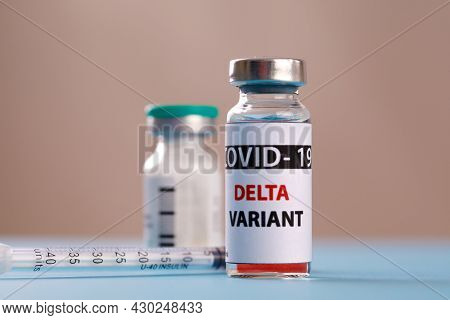 Vaccine bottles covid - 19 delta variant, vials medicine and syringe injection isolated on blue. Coronavirus DELTA 2019-ncov.