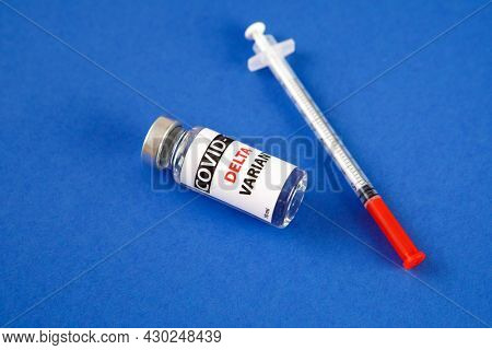 Vaccine bottles covid - 19 delta variant, vials medicine and syringe injection isolated on blue. Coronavirus DELTA 2019-ncov.