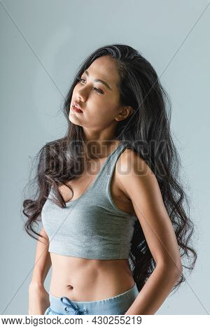 Asian Woman With Sexy Shapely Forms Posing In Trendy Look. Portrait Of A Brunette Model With Bright 