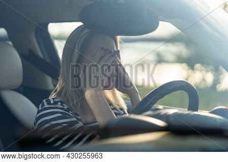 Stressed Woman Crying In Car. Middle Age Female Driver Feeling Headache Or Stress Hiding Face In Han