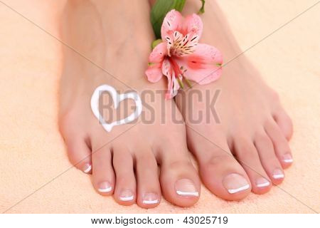 Gambe di donna bella con crema sul tovagliolo di peachy