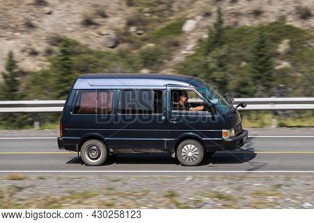Novosibirsk, Russia - August 08, 2021:   
Black Nissan Vanette  Driving Fast On Freeway In Highlands