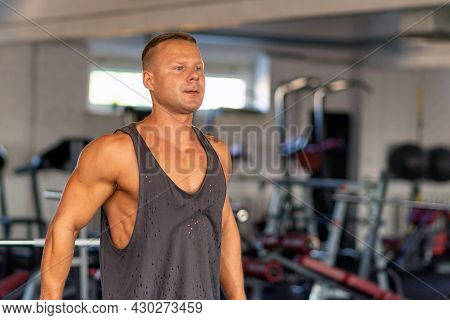 Fitness Man Warming Up In Gym. Male Doing Warm Up Stretching Workout On Gym Background.portrait Of A