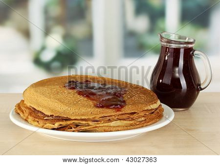 หวาน pancakes บนแผ่นกับแยมบนโต๊ะในห้องครัว