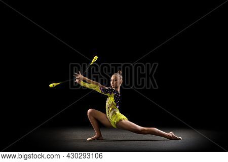 Portrait Of Little Girl, Rhythmic Gymnastics Artist In Bright Stage Costume Isolated On Dark Studio 