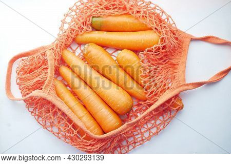 Fresh Carrots In Shopping Bag On White