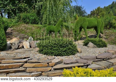 Green Sculptures Of Horse And Small Foal Created From Artificial Grass - Gardens Topiary. Creative I