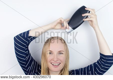 The Girl Looks In The Mirror At Her Oily Hair, Then Takes A Shampoo To Treat Oily Hair. Problematic
