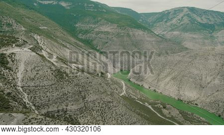 Top View Of Mountain Slopes With Dangerous Roads. Action. Winding Roads On Slopes Of Green Mountains