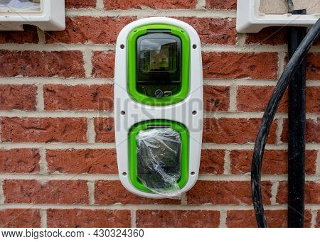 Electric Vehicle Domestic Charging Point Installed Outside Of The House On New Housing Development A