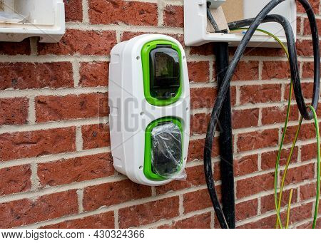Electric Vehicle Domestic Charging Point Installed Outside Of The House On New Housing Development A