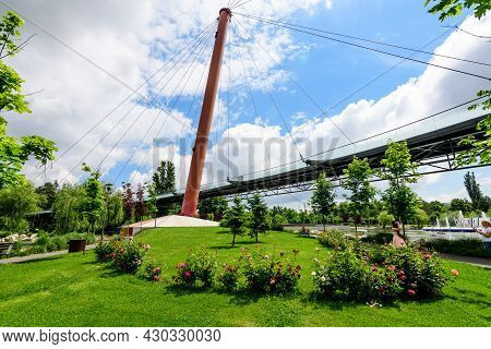 Landscape With The Modern Red Metallic Bridge, Lake And Vivid Green Trees In Drumul Taberei Park (pa