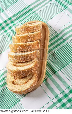 Rocambole, Sliced ​​rocambole Stuffed With Dulce De Leche On A Wooden Tray On A Table With Checkered