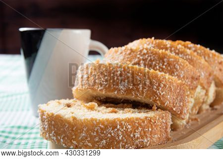 Rocambole, Sliced ​​roacambole Stuffed With Dulce De Leche On A Wooden Tray And A Cup On A Table Wit