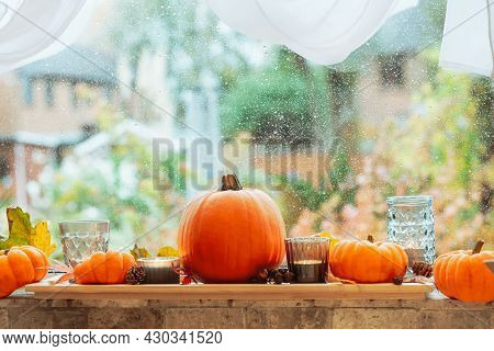 Autumn Cozy Mood Composition On The Windowsill. Pumpkins, Candles, Dried Leaves On The Wooden Tray A