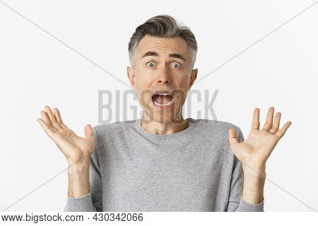 Close-up Of Scared Middle-aged Man, Looking Startled, Jumping And Screaming Frightened, Standing Amb