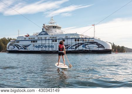 Victoria, Vancouver Island, British Columbia, Canada - August 15, 2021: Adventurous Woman Paddle Boa