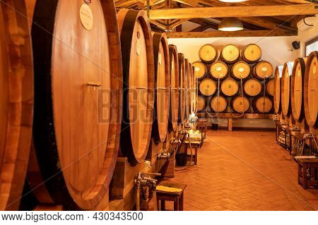 White, Rose And Red Wine In Barrels For Sale In Wine Cellars In Italy