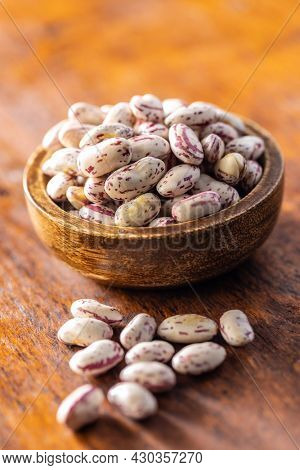 Cranberry beans. Borlotti beans in bowl on wooden table.