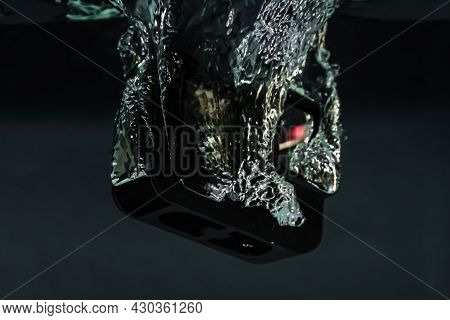 Creative Underwater Photo Of Action Camera, Drowning In The Water. Black Background