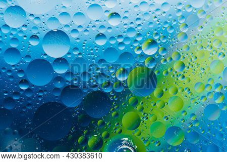 Oil With Bubbles On Vibrant Green And Blue Background. Abstract Space Background. Soft Selective Foc