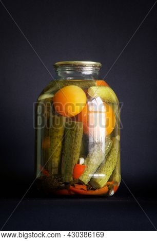 Canned Cucumbers And Tomatoes In A Large Three-liter Jar On A Black Background. The Concept Of Homem