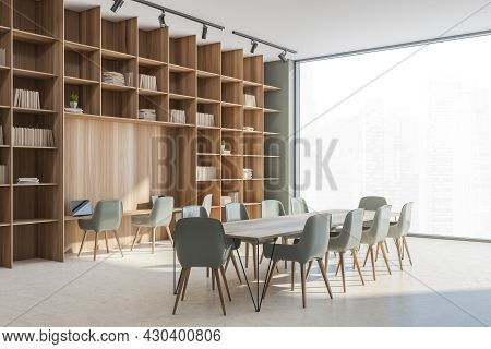 Corner View On The Large Wooden Bookcase With Niche Desk And Conference Table In The Beige And Subdu