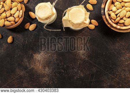 Plant Based Almod Milk In Bottles On Brown Background. Copy Space. Top View