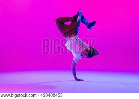 Young Stylish Man, Hip-hop Dancer Dancing Solo In Modern Clothes Isolated Over Bright Magenta Backgr