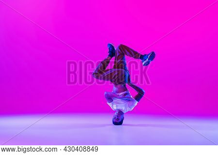 Portrait Of Young Man, Break-dance Dancer Dancing Solo In Modern Clothes Isolated Over Bright Magent