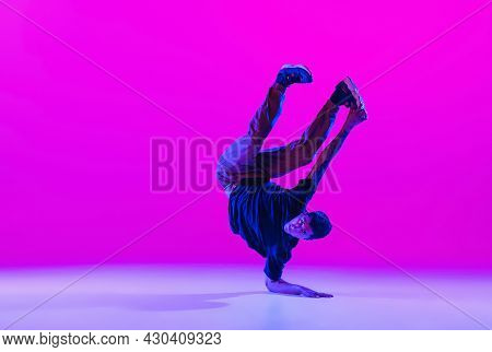 Young Stylish Man, Hip-hop Dancer Dancing Solo In Modern Clothes Isolated Over Bright Magenta Backgr