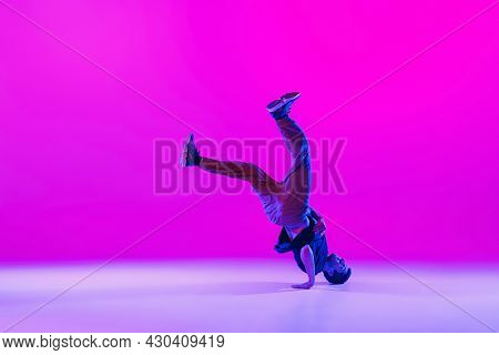 Young Stylish Man, Hip-hop Dancer Dancing Solo In Modern Clothes Isolated Over Bright Magenta Backgr