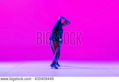 Young Stylish Man, Hip-hop Dancer Dancing Solo In Modern Clothes Isolated Over Bright Magenta Backgr