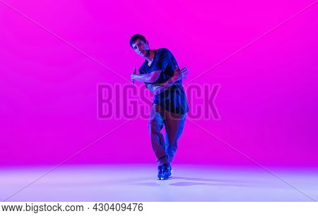 Young Stylish Man, Hip-hop Dancer Dancing Solo In Modern Clothes Isolated Over Bright Magenta Backgr