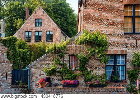 Old housesof Begijnhof Beguinage with flowers in Bruges town. Brugge, Belgium