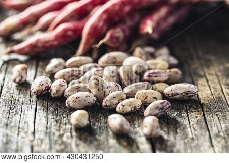 Cranberry beans. Borlotti beans. Beans pods on wooden table.
