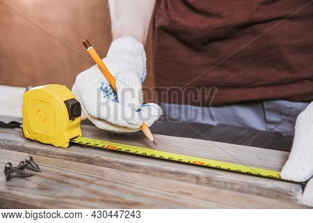 Exact Measured. Close Up Of Young Male Carpenter In Gloves Making Measurements On The Wooden Plank B