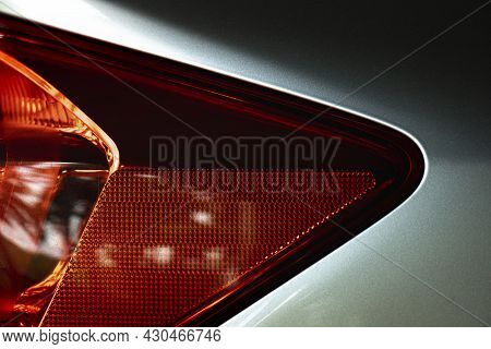 Luxurious Red Tail Lamp Of A Silver Bronze Car. Environment Of Dark Tone.