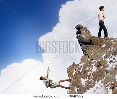 Imagem de busionessman e empresária puxando a corda no topo da montanha