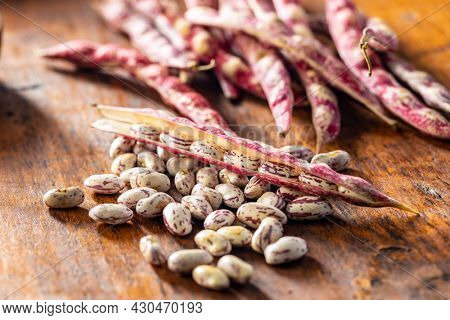 Cranberry beans. Borlotti beans. Beans pods on wooden table.