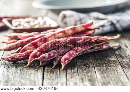 Cranberry beans. Borlotti beans. Beans pods on wooden table.