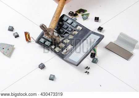 An Angry, Unstable Man Smashes A Calculator With A Hammer. His Hand Hits The Plastic Casing Of The E
