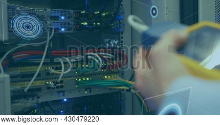 Multiple round scanners against mid section of man working in computer server room. cyber security and computing technology concept