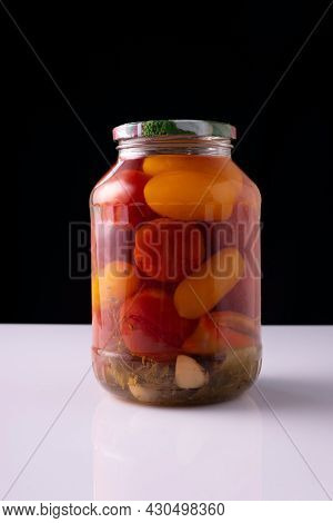 Canned Vegetables In A Jar On A White Table And Black Background.