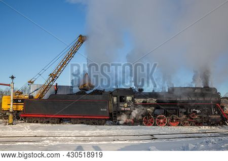 Sortavala, Russia - March 10, 2021: Loading Of Coal Into A Steam Locomotive Tender At The Sortavala 