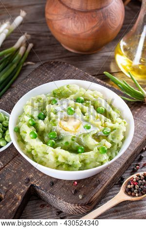 Delicate Mashed Potatoes With Green Peas, Flavored With Butter And Spices On A Wooden Table. Delicio