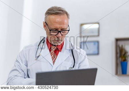 Stylish Handsome Medicine Man In Glasses. Attractive Medical Worker Working With Laptop In Glasses.