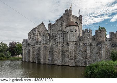 Gent, Flanders, Belgium - July 30, 2021: West Side Of Gray Gravensteem Medieval Stone Castle Under B
