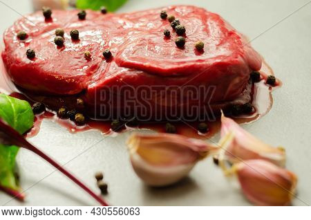 Raw Beef Sirloin Steak With Peppercorns And Garlic Prepared For Frying