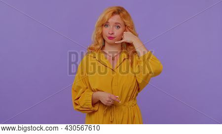 Call Me, Here Is Contact Number. Cheerful Cute Girl In Yellow Dress Looking At Camera Doing Phone Ge